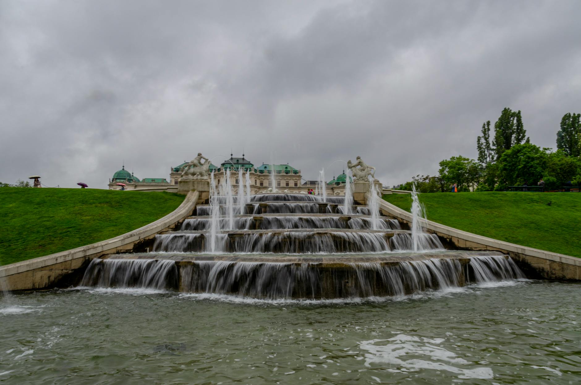 Mała fontanna solarna w oczku wodnym w ogrodzie latem