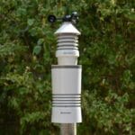 Bezprzewodowa stacja pogodowa wśród zielonych liści w ogrodzie