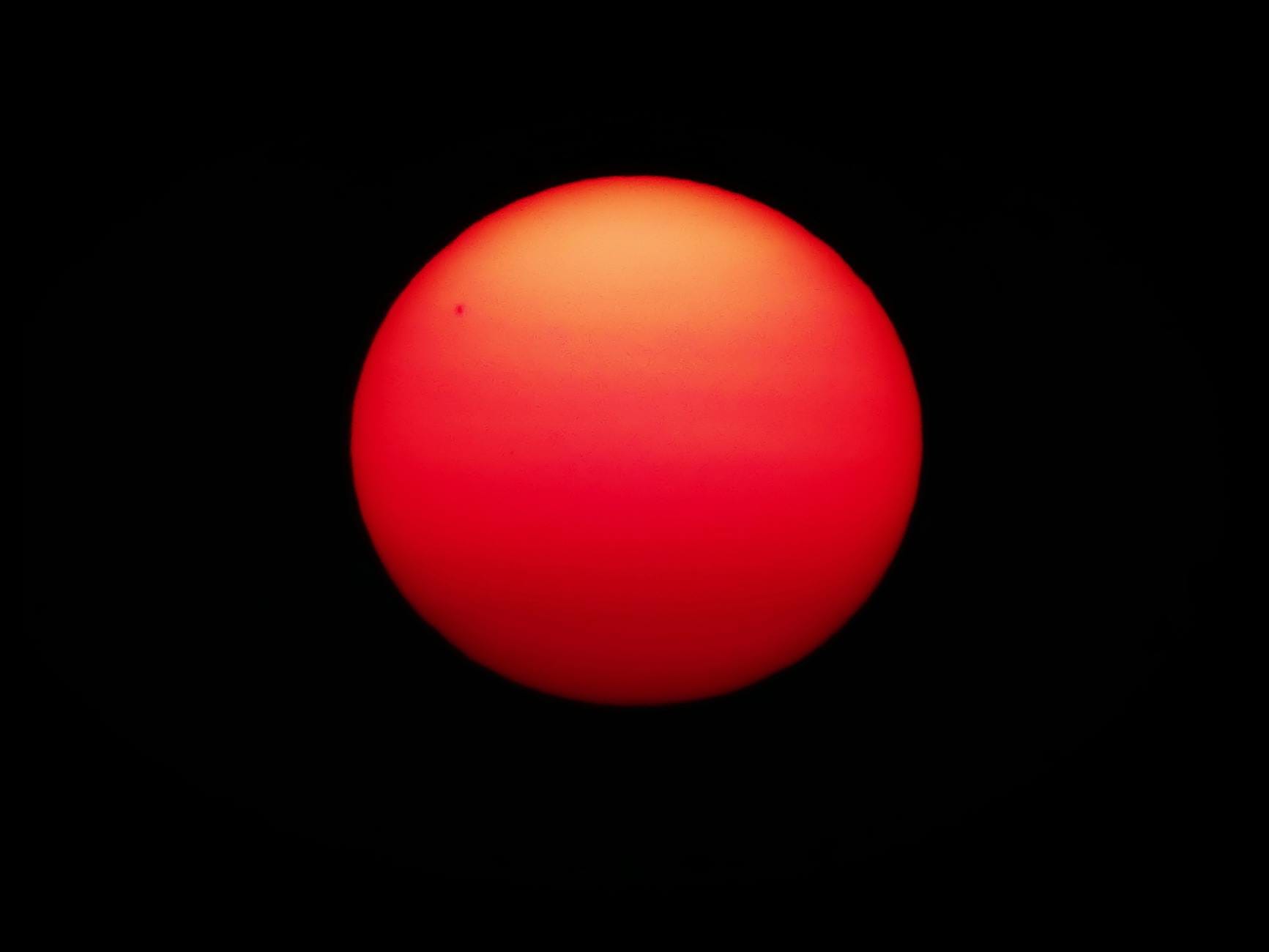 Czerwone słońce na czarnym nocnym niebie tworzące dramatyczną scenerię