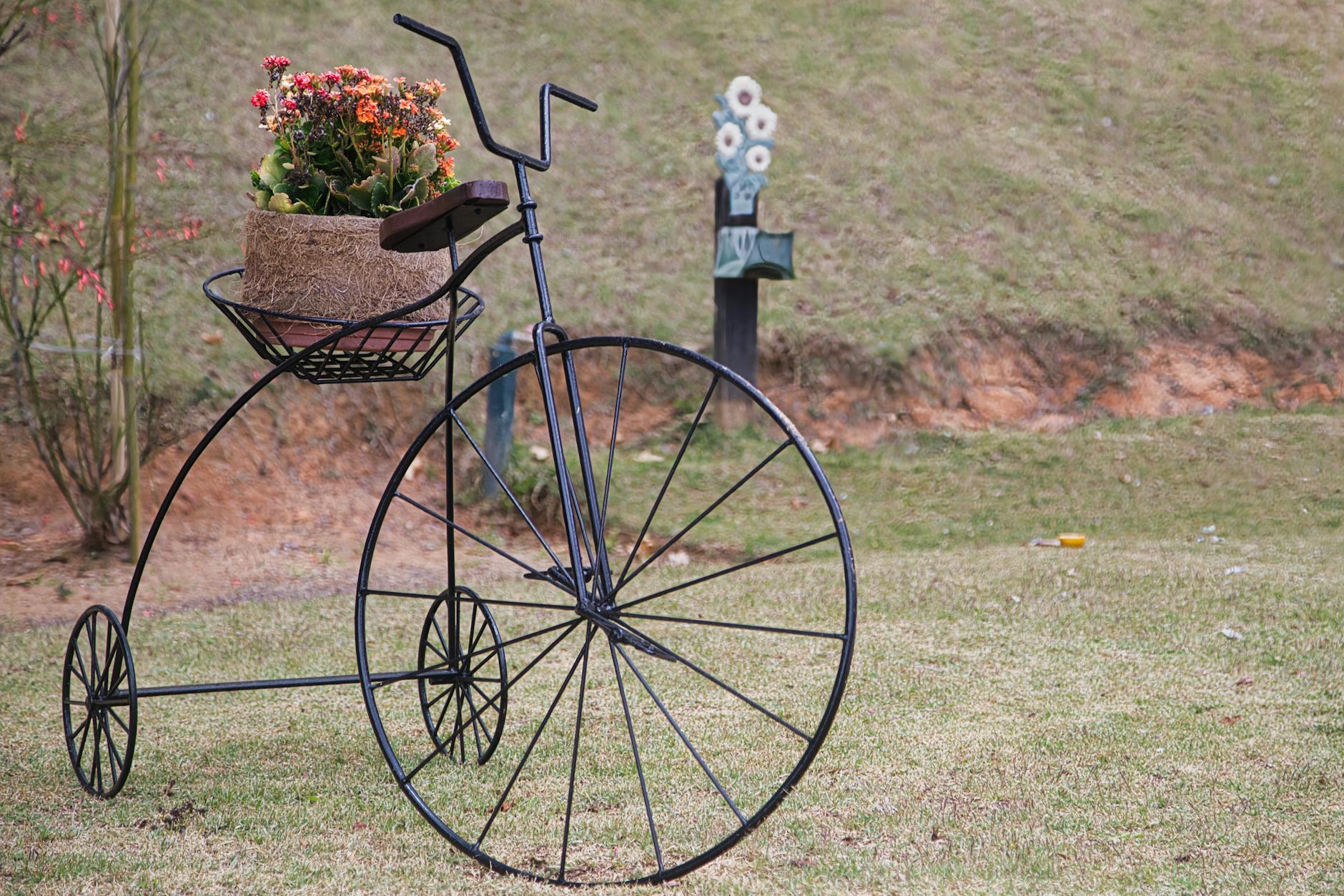 Rowerowa kwietnikowa dekoracja z barwnymi kwiatami w ogrodzie przydomowym